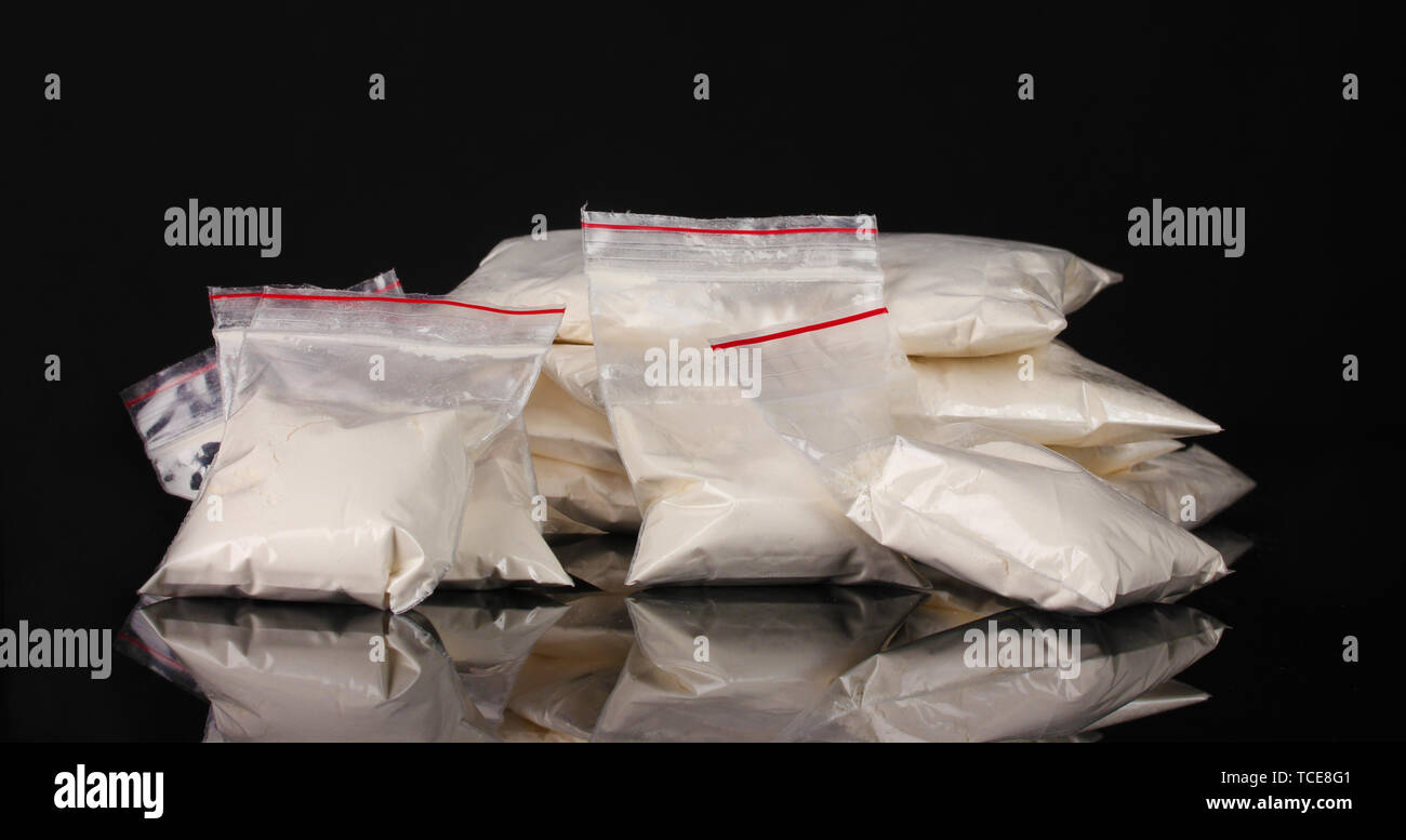 La cocaina in pacchetti su sfondo nero Foto Stock