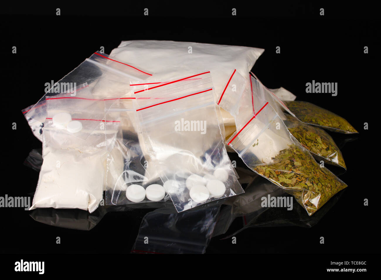Cocaina e marijuana in pacchetti su sfondo nero Foto Stock