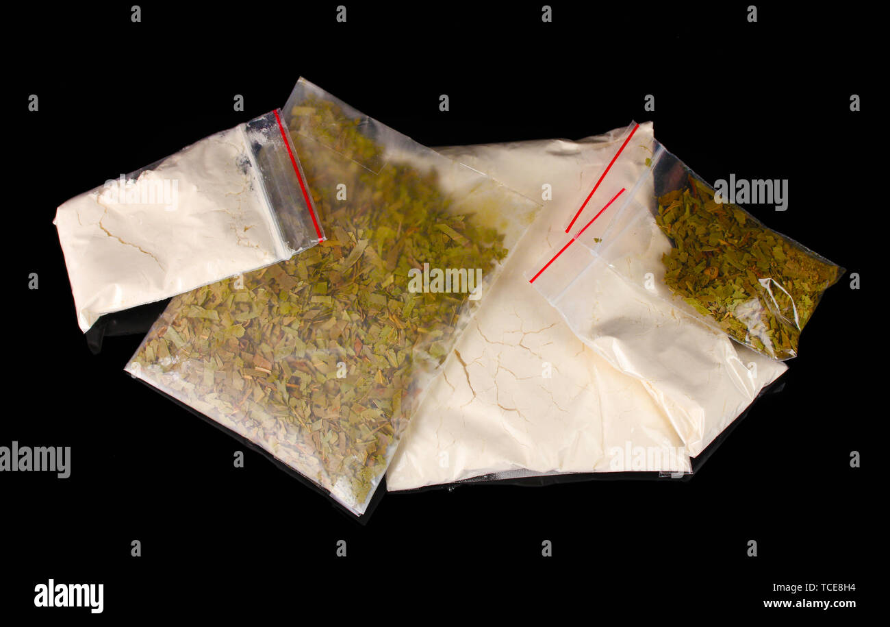 Cocaina e marijuana in pacchetti su sfondo nero Foto Stock