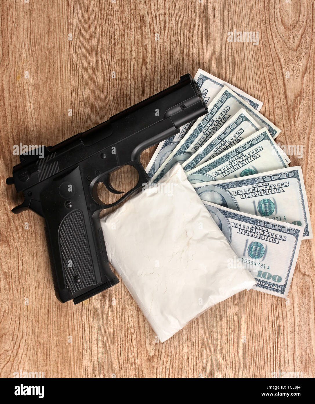 La cocaina in pacchetto, dollari e pistola su sfondo di legno Foto Stock