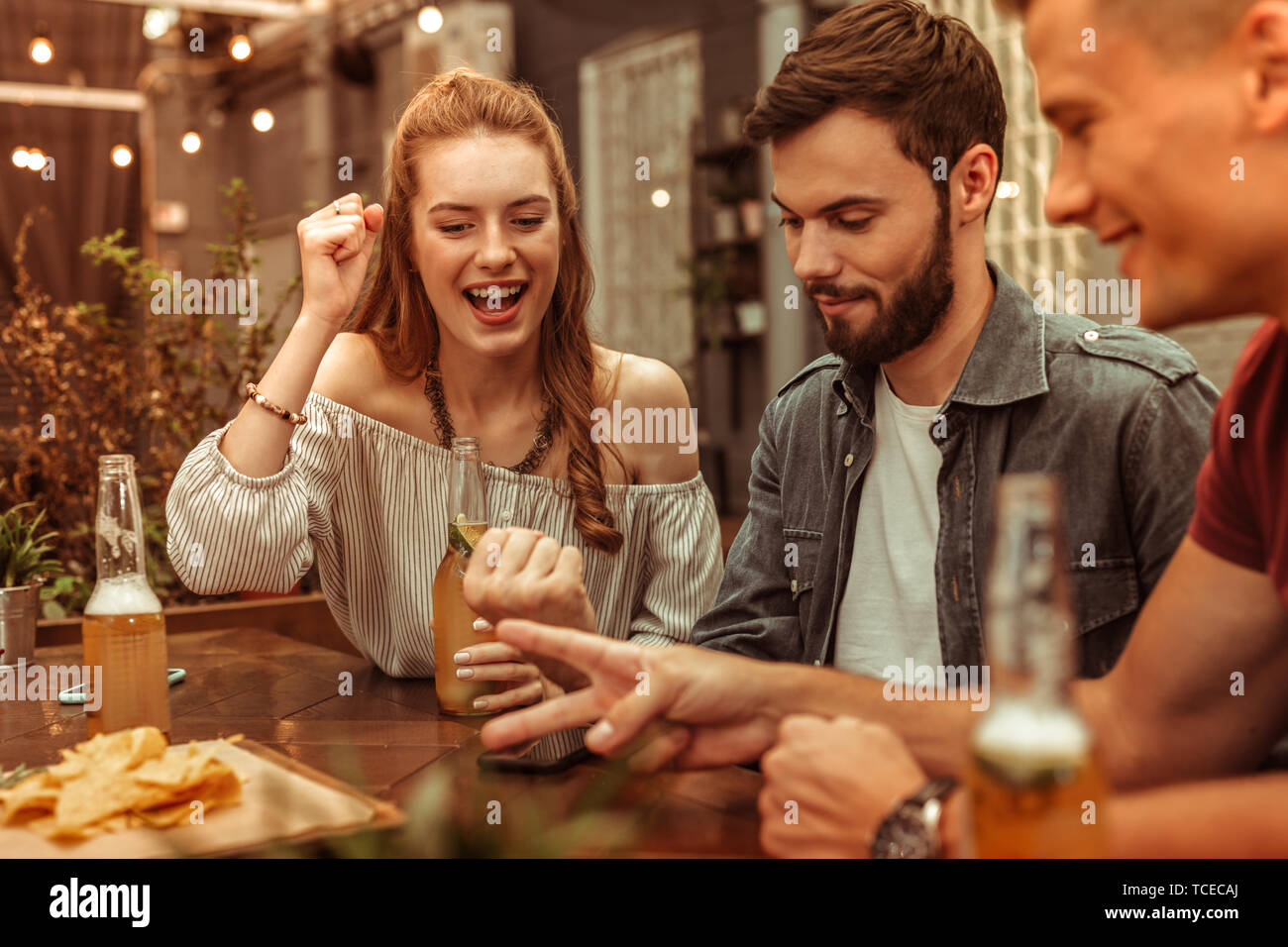 Divertirsi con gli amici. Affascinante con i capelli lunghi nice-attraente giovane donna e due felice ridere attraente ragazzi divertirsi e giocare a ba Foto Stock