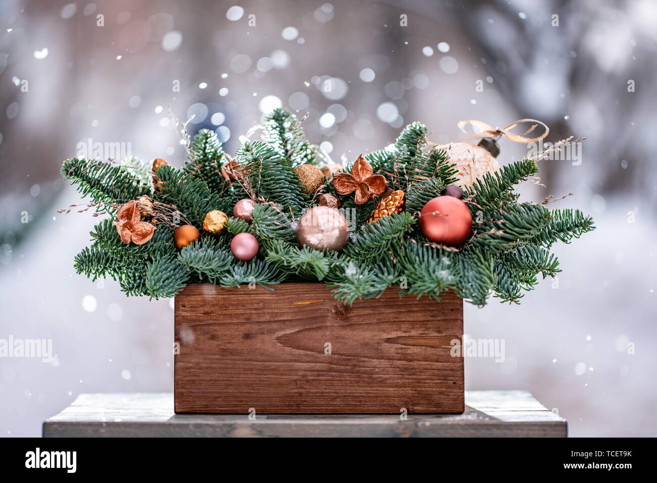 Bella disposizione festosa di abete rosso fresco con sfera di giocattoli in un rustico di una scatola di legno. Il Natale di umore. Nevica in inverno Foto Stock