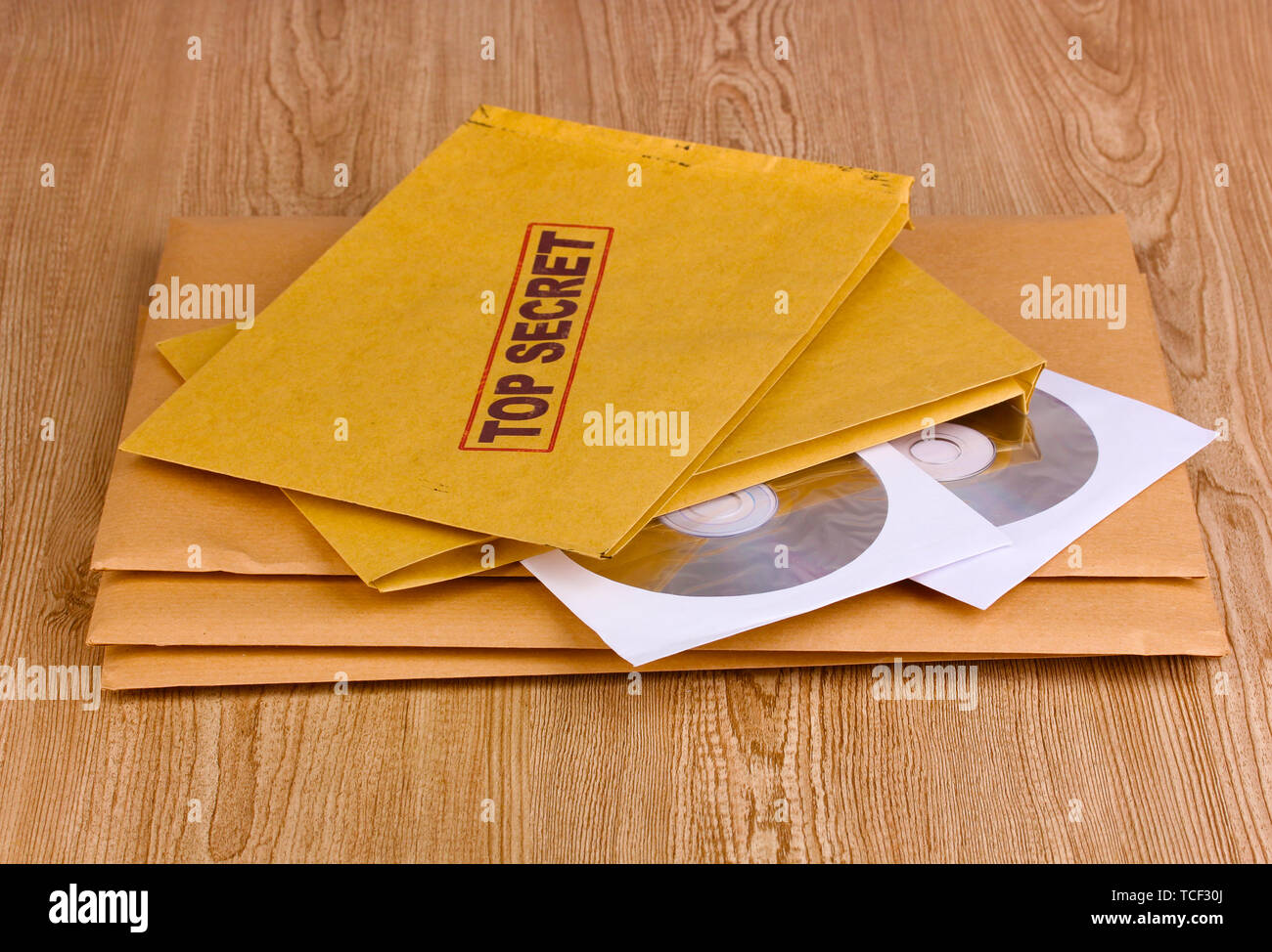 Le buste con il lato superiore top secret timbro con dischi CD su sfondo di legno Foto Stock