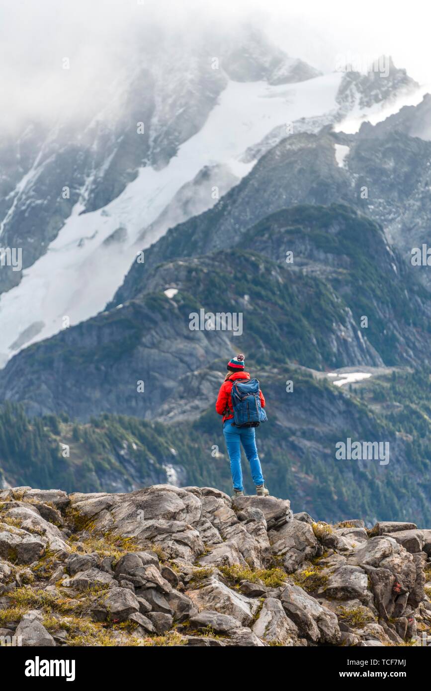 Escursionista femmina off Mt. Shuksan con neve e ghiacciai, Mt. Baker-Snoqualmie Foresta Nazionale, Washington, USA, America del Nord Foto Stock