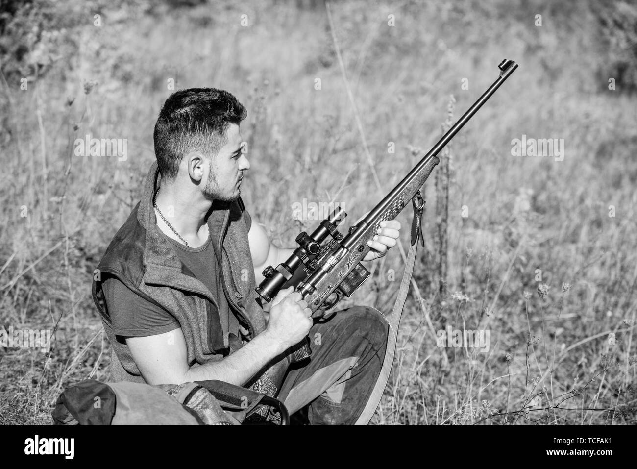 Uomo di carica fucile da caccia. Attrezzature di caccia del concetto. Caccia hobby e tempo libero. Cacciatore con fucile in cerca di animale. Hunter khaki vestiti pronto per la caccia la natura dello sfondo. Caccia al trofeo. Foto Stock