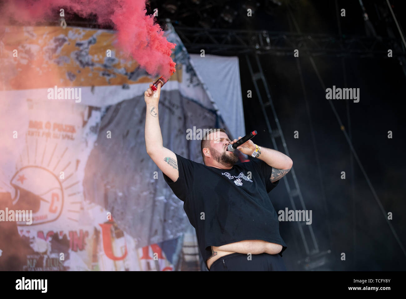 Norimberga, Germania. 07Th Giugno, 2019. Jan 'Monchi' Gorkow, cantante del tedesco della band punk "Feine Sahne Fischfilet', sorge sul palco a open-air festival 'Rock im Park' e mantiene una torcia di fumo con fumo di rosso nella sua mano. Il festival di musica fino al 9 giugno 2019. Credito: Daniel Karmann/dpa/Alamy Live News Foto Stock