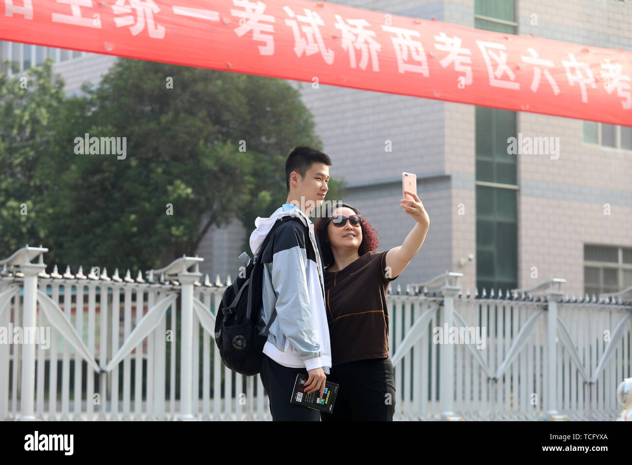 Shijiazhuang cinese nella provincia di Hebei. Il 7 giugno, 2019. Un examinee prende un selfie con il suo genitore in corrispondenza di una sede di esame al n. 6 Middle School di Shijiazhuang, città del nord della Cina nella provincia di Hebei, 7 giugno 2019. La Cina del collegio nazionale esame di ammissione o Gaokao, iniziato venerdì di quest'anno. Credito: Liang Zidong/Xinhua/Alamy Live News Foto Stock