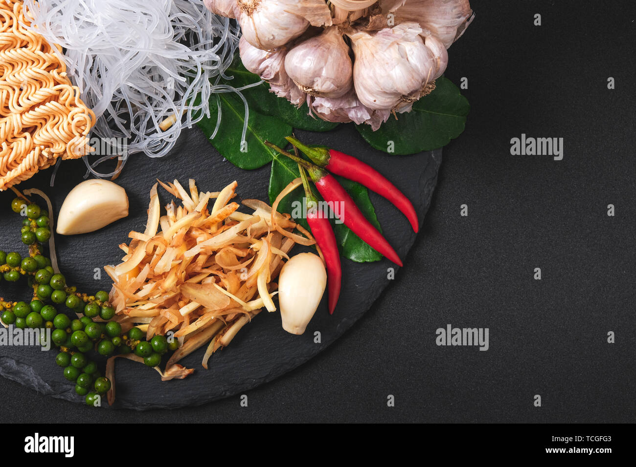 Vista dall'alto di ingredienti freschi. La cucina salutistica sfondo con verdura biologica per vegan su nero ardesia . Lo zenzero , Aglio , peperoncino fresco ed essiccato n Foto Stock