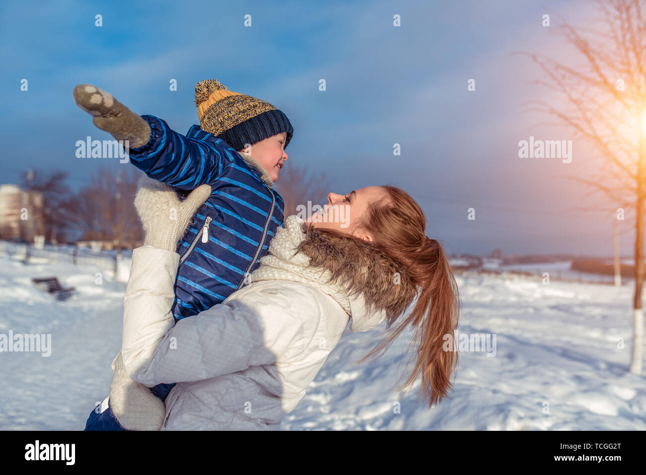 La mamma con un ragazzo figlio di 3 anni, in inverno in una coppia su di una collina, l'aria fresca. Week-end di vacanza parco della città. Essi svolgono aeroplani, gettarle, divertirsi Foto Stock