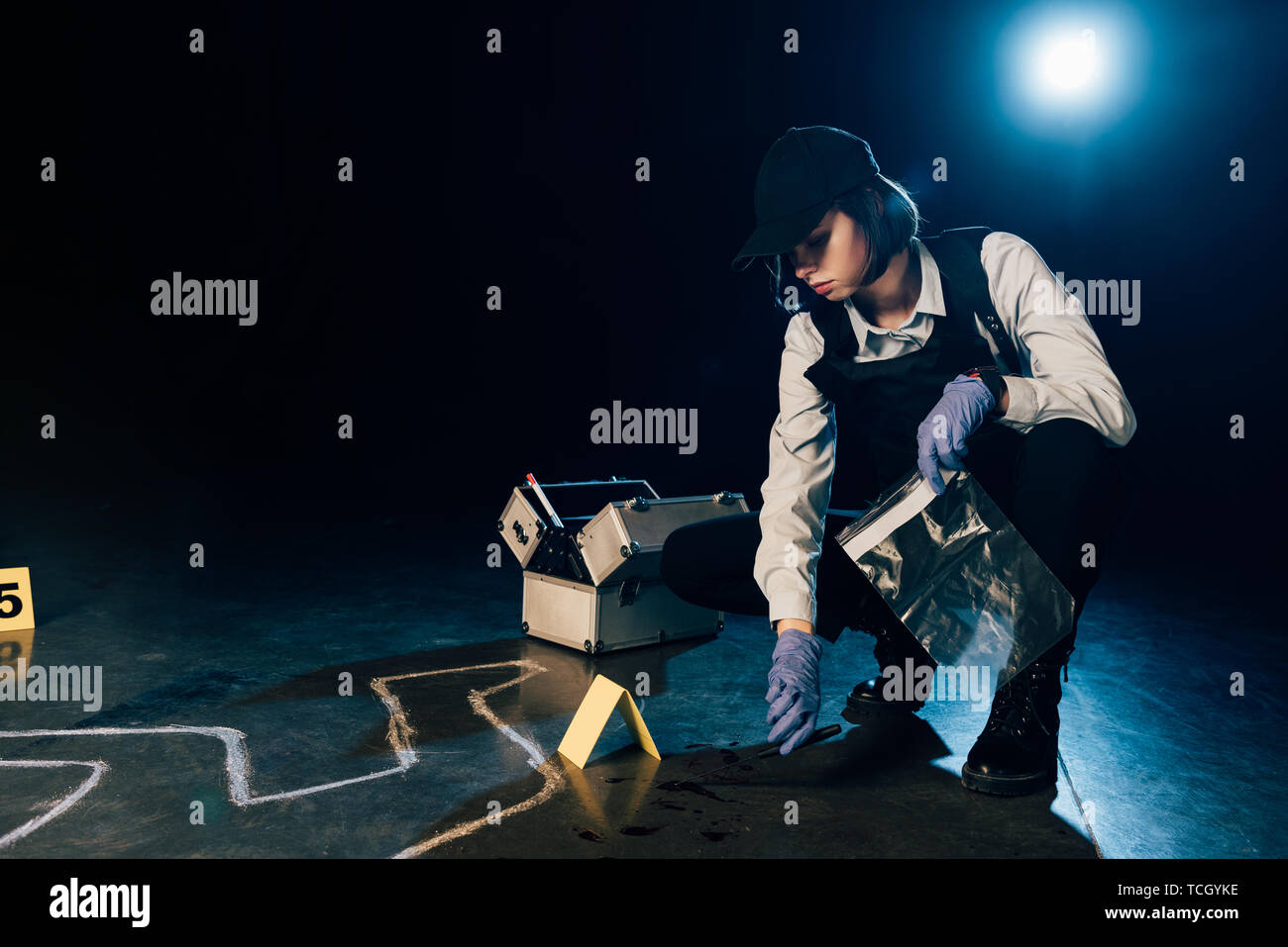 Sperimentatore tenendo il coltello e sacchetto ziploc alla scena del crimine Foto Stock