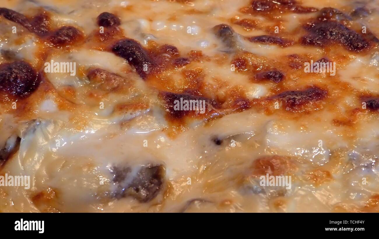 La cottura la Moussaka con verdure, formaggi e besciamella, con punto di ebollizione a caldo in un forno. Greco tradizionale piatto. Chiudere fino a rimpicciolire. Foto Stock