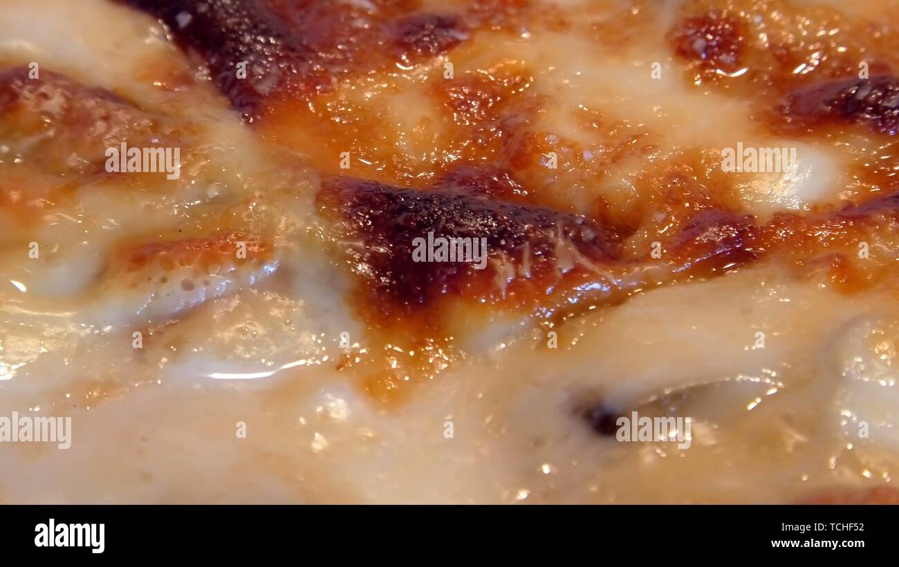 La cottura la Moussaka con verdure, formaggi e besciamella, con punto di ebollizione a caldo in un forno. Greco tradizionale piatto. Chiudere fino a rimpicciolire. Foto Stock