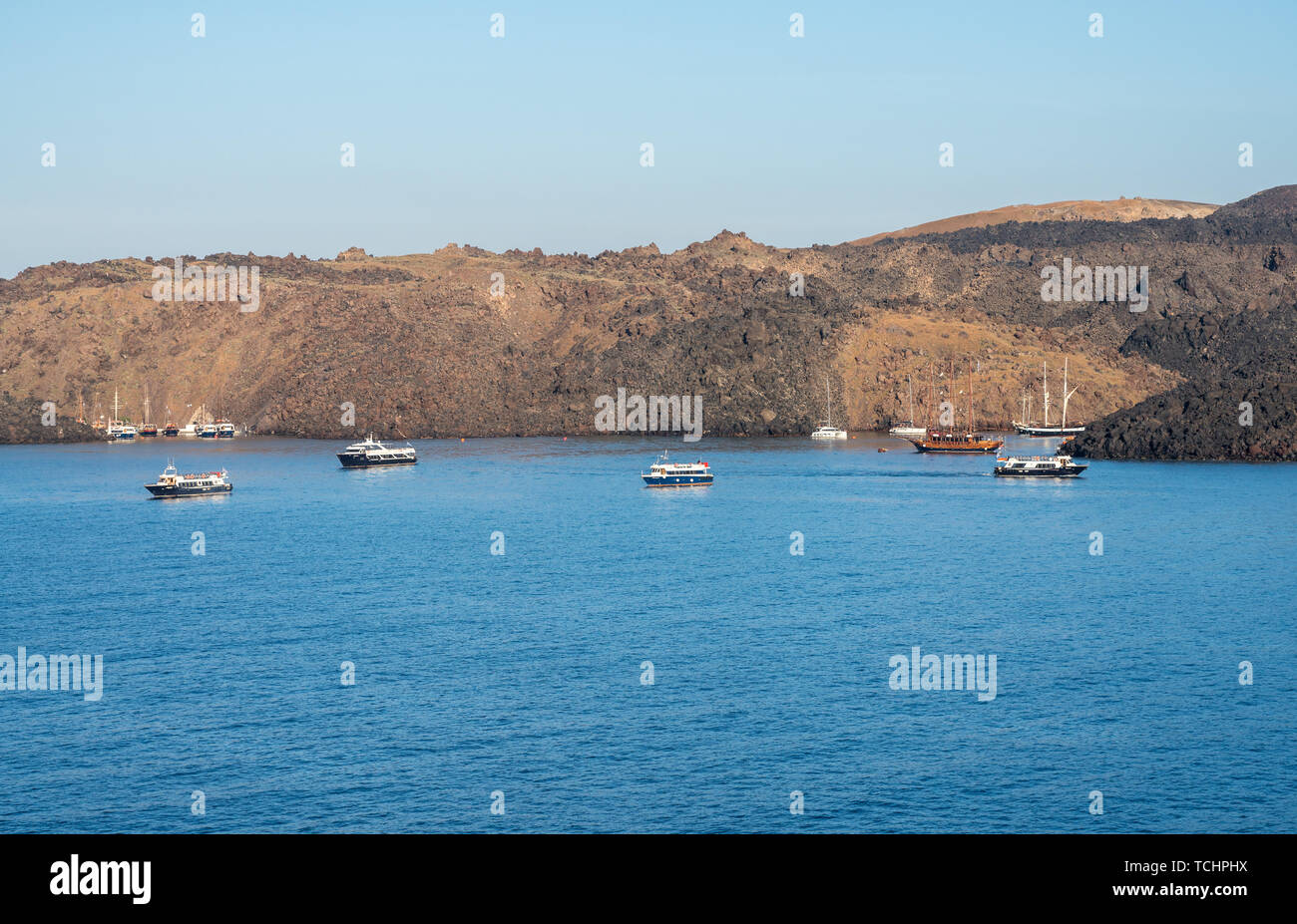 Piccole barche nel porto di caldera vulcanica isola di Santorini Foto Stock