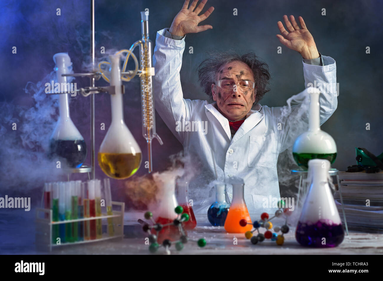 Lo scienziato pazzo con faccia sporca nel laboratorio circondato dal fumo da l'esplosione Foto Stock