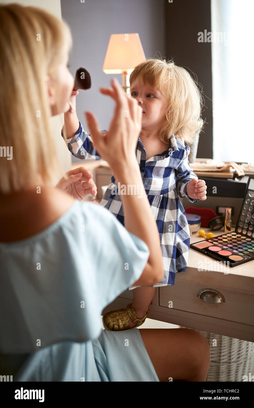 Cute girl abbellisce la sua madre con il make up Foto Stock