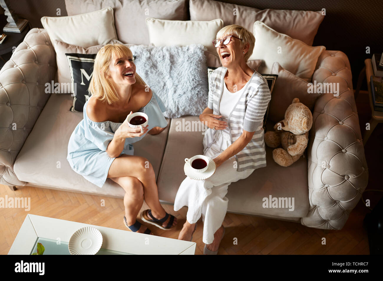 Due femmina felice ridendo e godendo con caffè Foto Stock