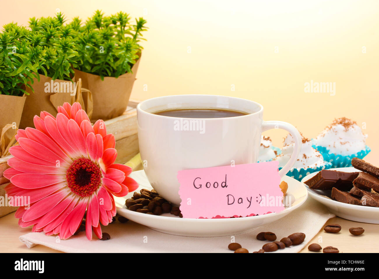 Tazza di caffè e gerbera fagioli, bastoncini di cannella sul tavolo di legno Foto Stock