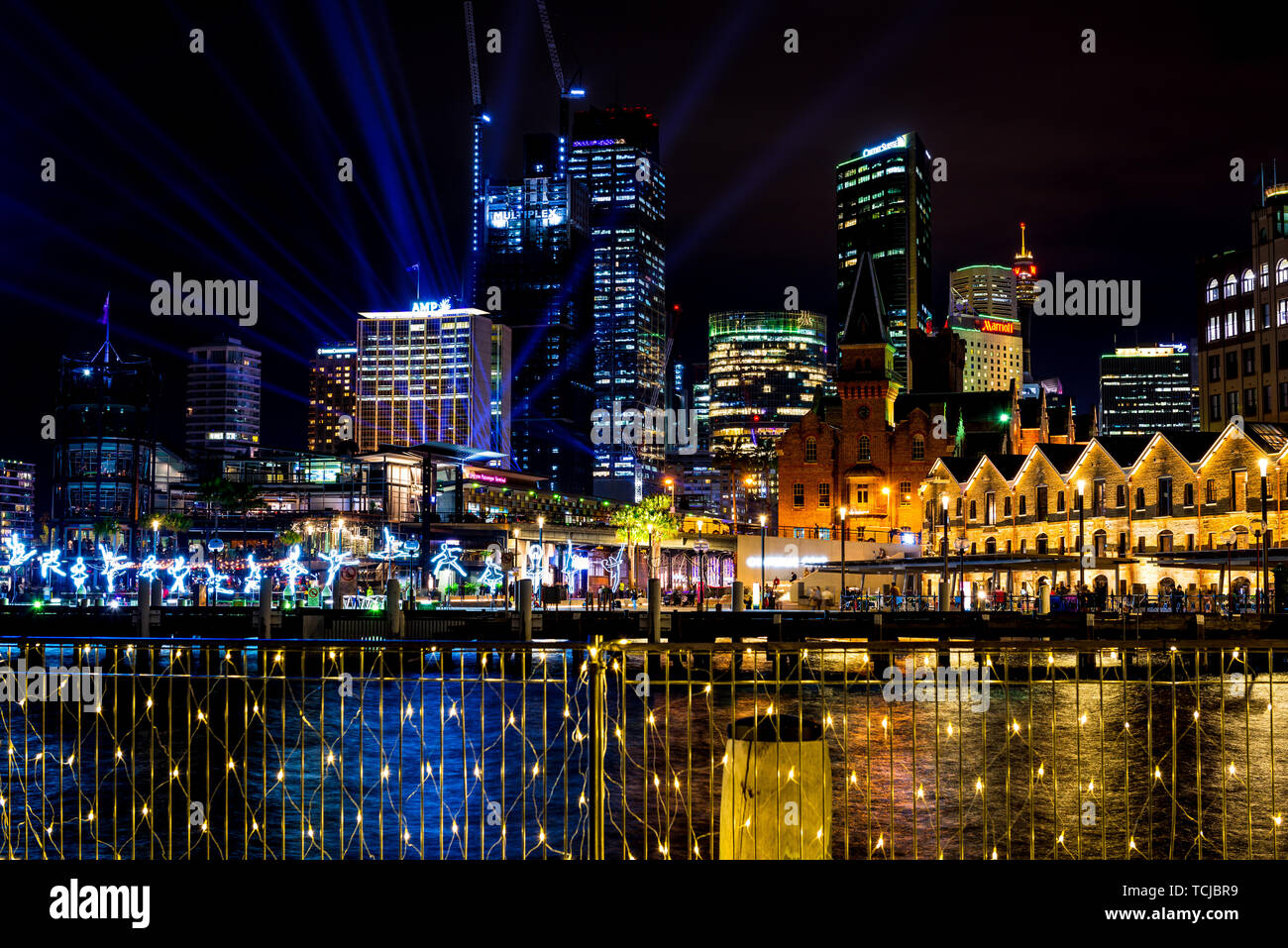 I ballerini di salto in tutta l'acqua in Sydney, con lo skyline della città in lontananza durante il vivace, il popolare annuale festival della luce. Sydney, Australia Foto Stock