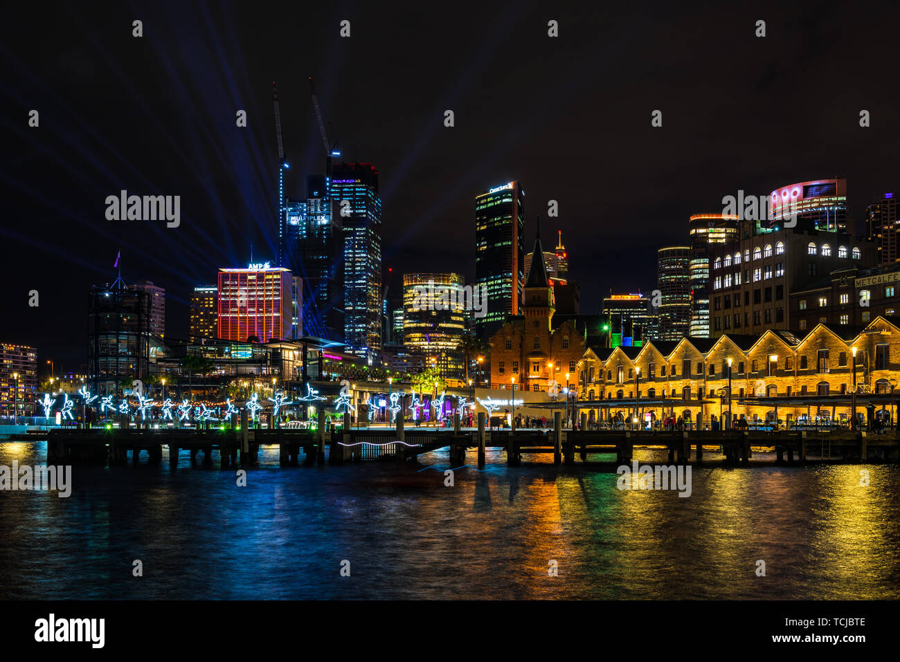 I ballerini di salto in tutta l'acqua in Sydney, con lo skyline della città in lontananza durante il vivace, il popolare annuale festival della luce. Sydney, Australia Foto Stock