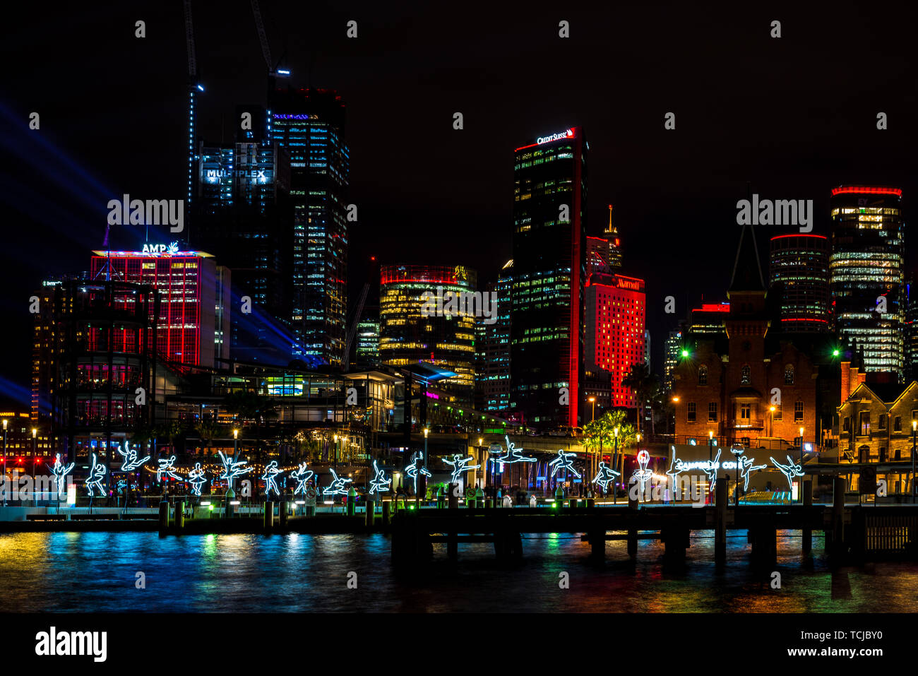 I ballerini di salto in tutta l'acqua in Sydney, con lo skyline della città in lontananza durante il vivace, il popolare annuale festival della luce. Sydney, Australia Foto Stock