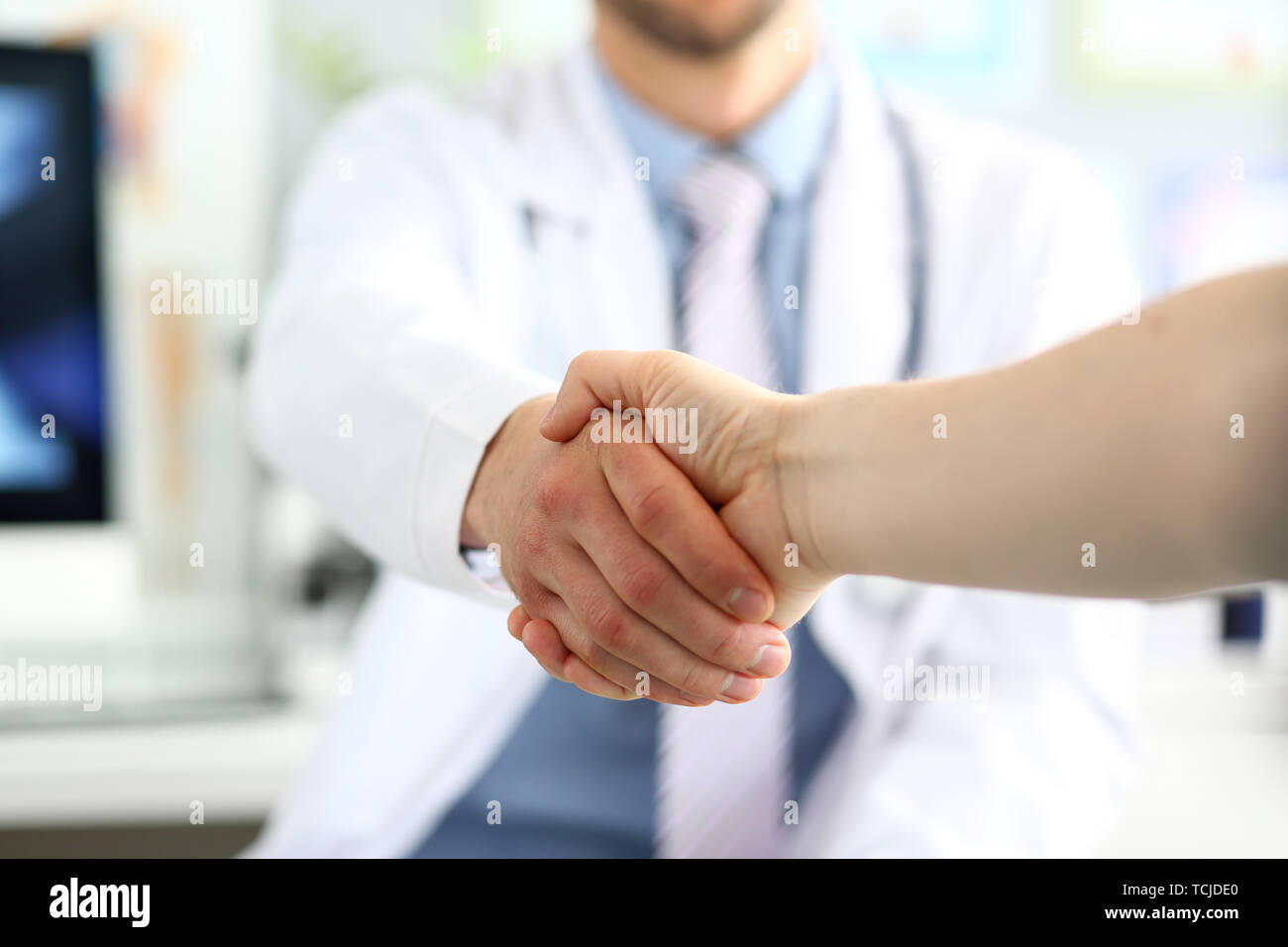 Il medico e il paziente handshake Foto Stock