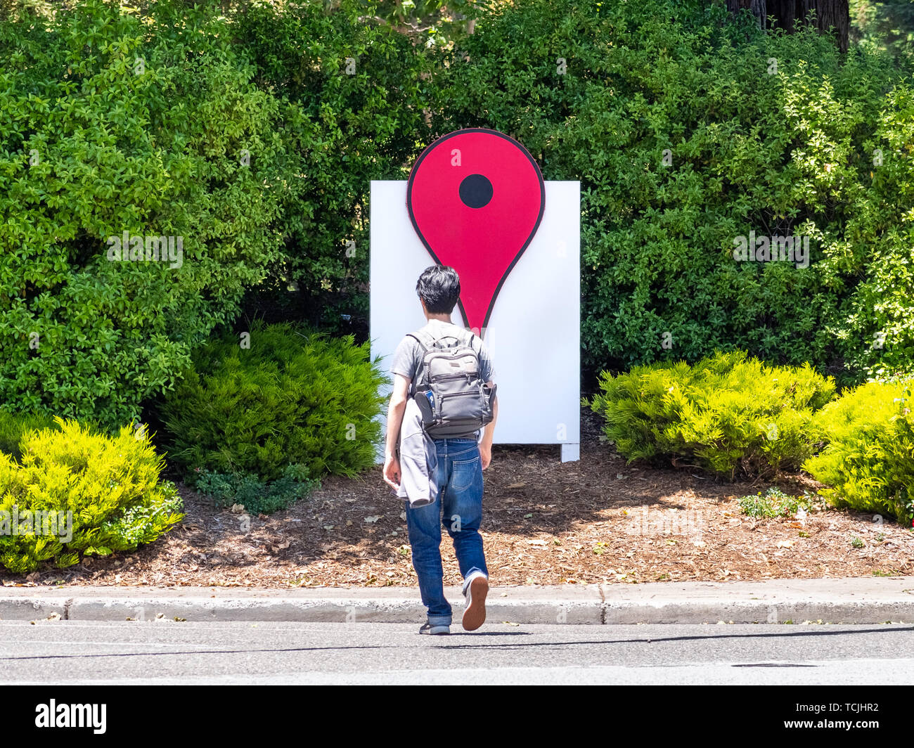 Giugno 4, 2019 Mountain View / CA / USA - Le mappe di Google Icona vicino i loro uffici in campus Google nella Silicon Valley; dipendente attraversando la strada Foto Stock