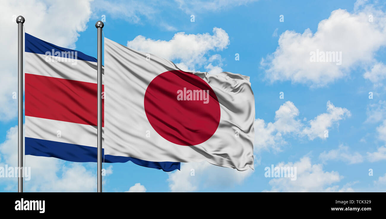 Costa Rica e Giappone bandiera sventolare nel vento contro bianco torbido cielo blu insieme. Concetto di Diplomazia e relazioni internazionali. Foto Stock