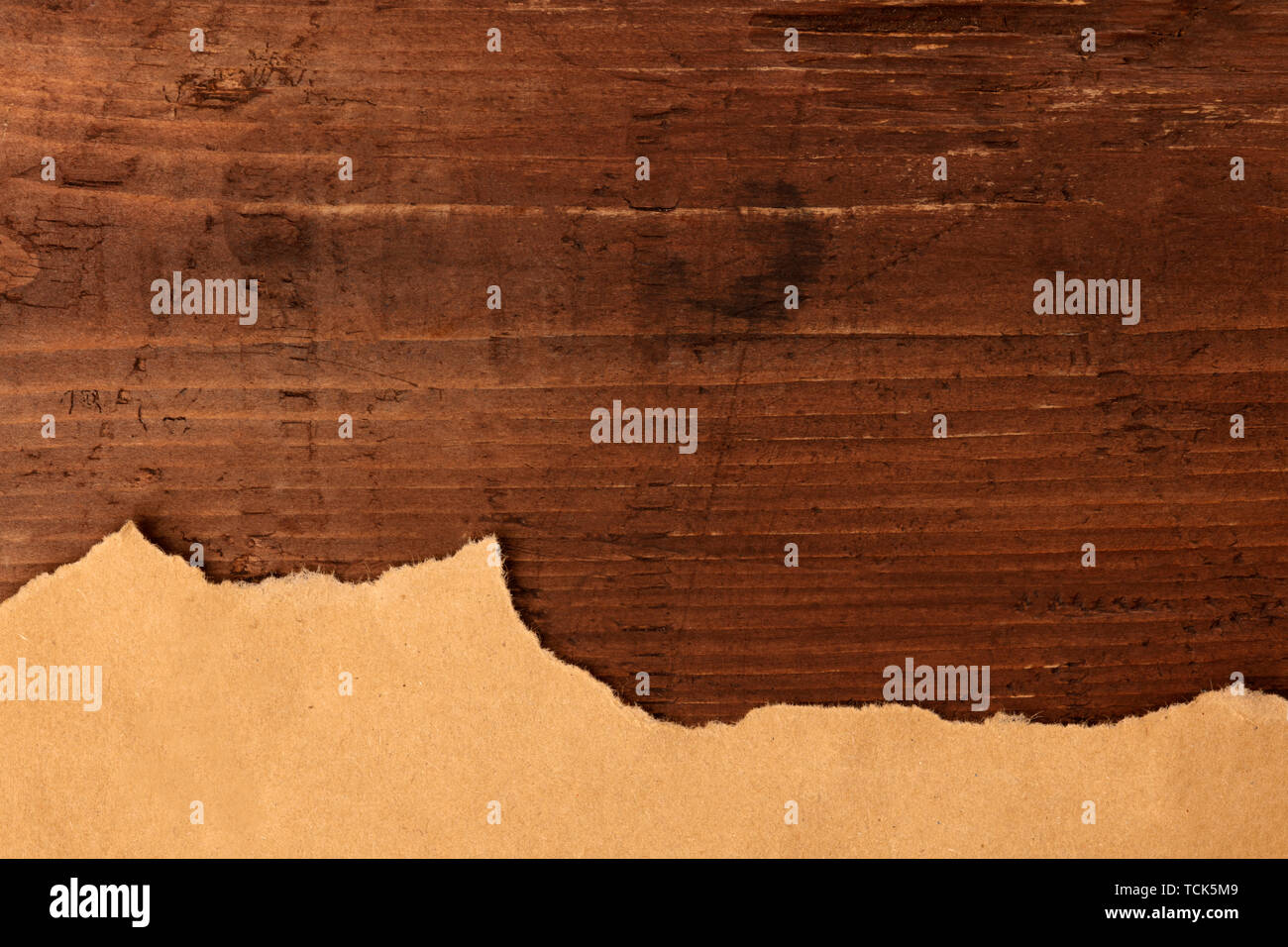 Strappato marrone carta kraft, ripresa dall'alto su una scuri in legno rustico sfondo, un design grunge modello con un posto per il testo Foto Stock