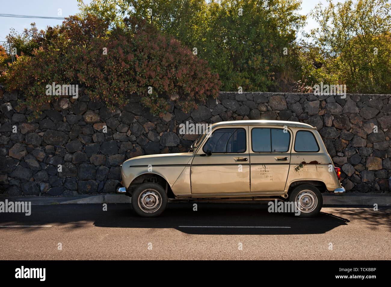 Leggermente danneggiato Renault R4 in piedi su una strada di fronte siepi dense sull'isola delle Canarie di La Palma, Spagna Foto Stock