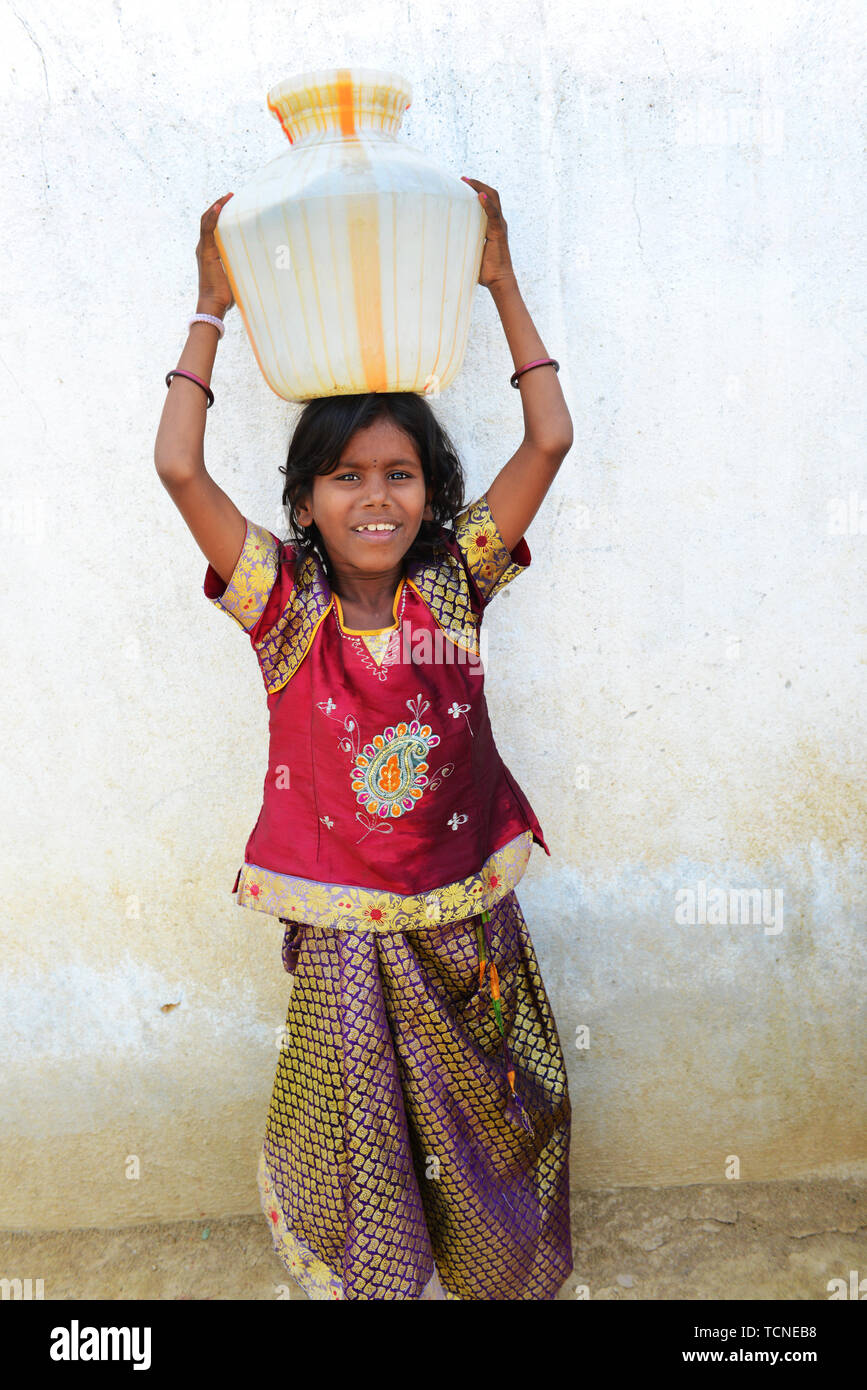 Una ragazza Tamil che porta un grande recipiente di acqua sulla sua testa. Foto Stock