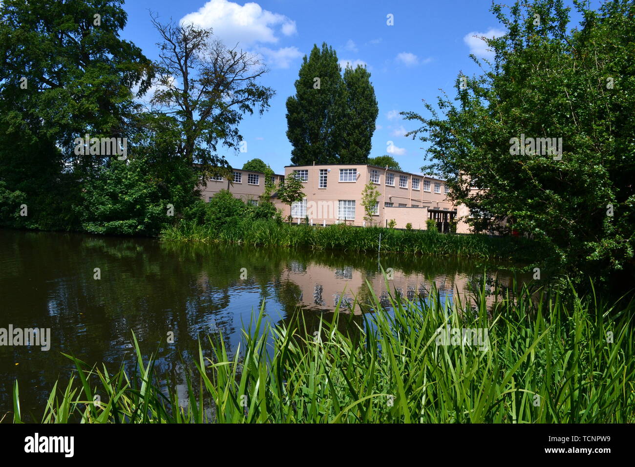 Vista sul lago per gli edifici e le malghe a Bletchley Park, Milton Keynes, Buckinghamshire, UK. Ora essi ospitare mostre. Foto Stock