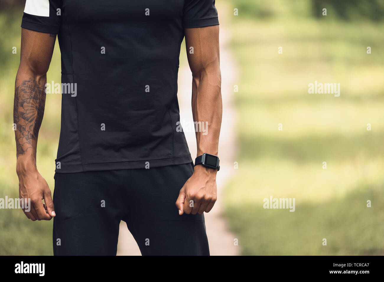 Afro-uomo nel fustellato T-Shirt in piedi all'aperto Foto Stock