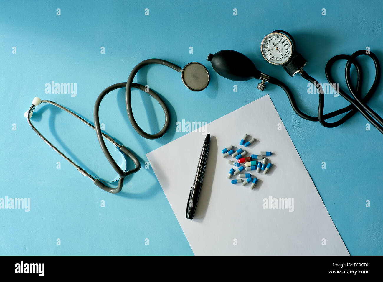 Foglio bianco di carta con la penna nera e colorata pillole diverse. Foto Stock