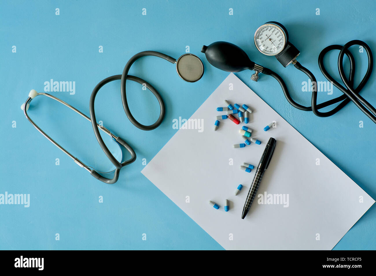 Foglio bianco di carta con la penna nera e colorata pillole diverse. Foto Stock