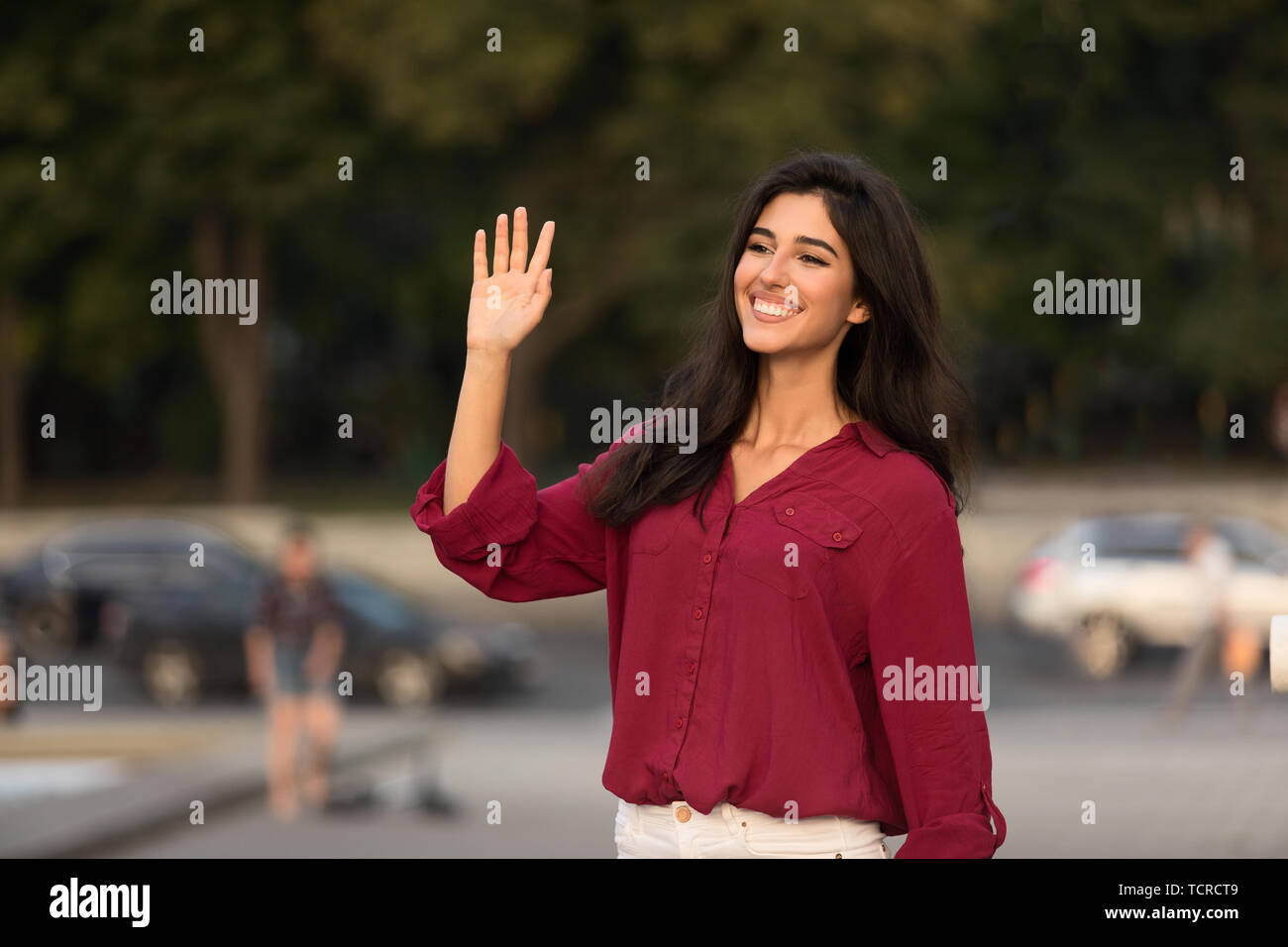 Donna felice saluto e agitando la mano, dicendo ciao Foto Stock