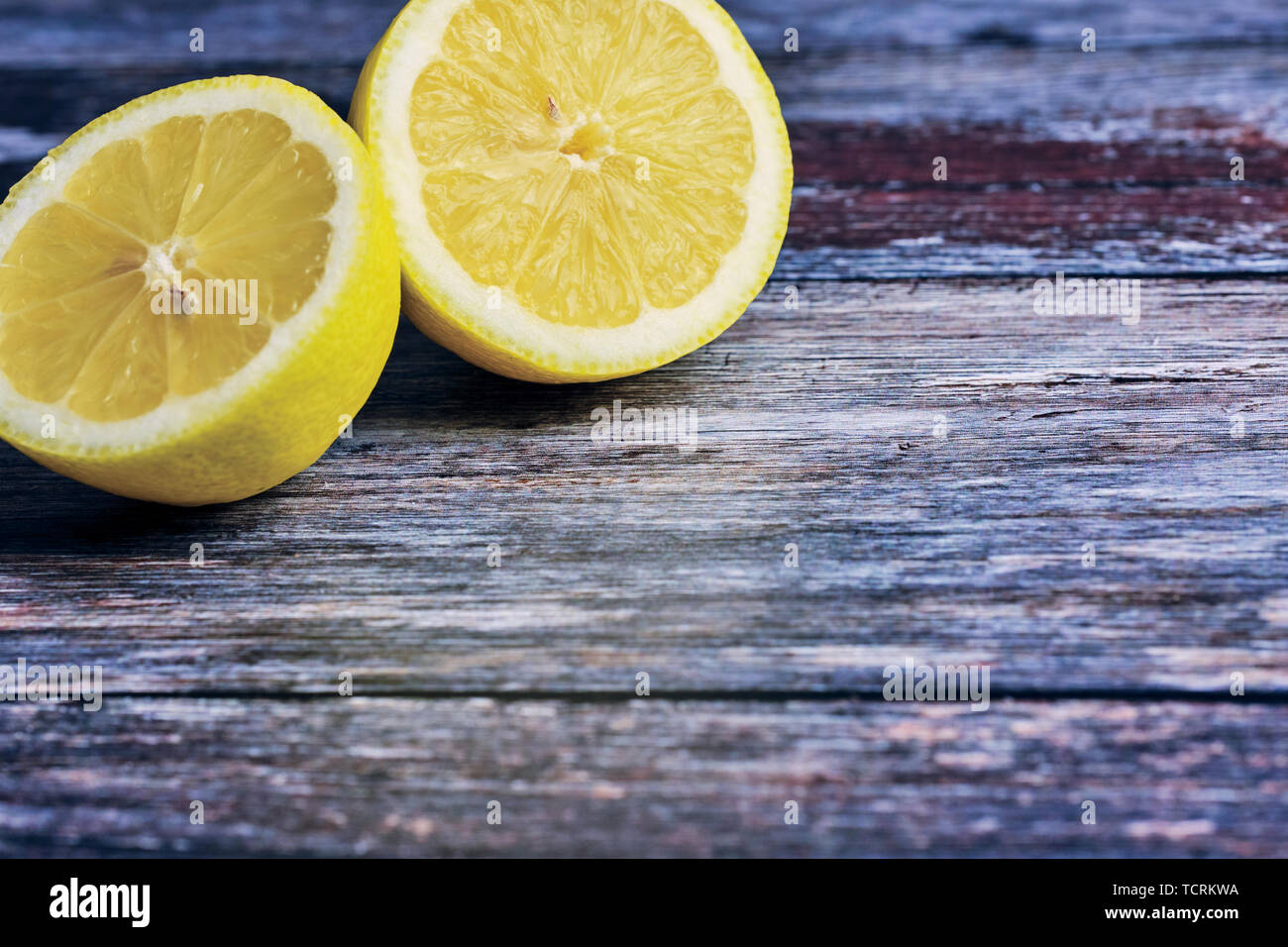 Due metà di un limone su sfondo di legno con spazio di copia Foto Stock