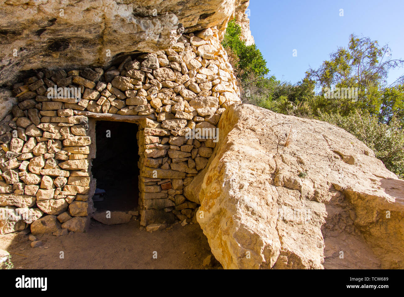 Vecchia caverna contrabandist casa costruita su una rupe a Moraig beach, in Benitatxell, Spagna Foto Stock
