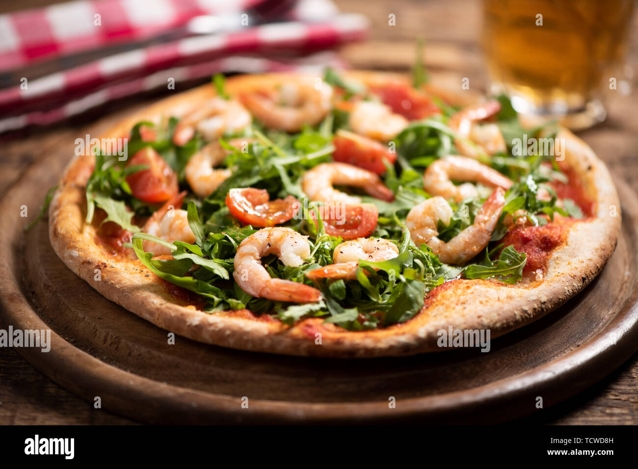 Pizza coperta con roquette e gamberetti sul tavolo di legno vicino fino  Foto stock - Alamy