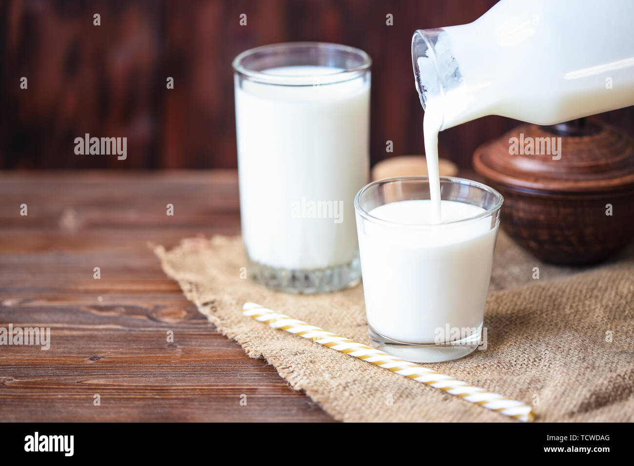 Versando in casa il kefir, yogurt con probiotici probiotico di freddo latticini fermentati bevanda alla moda di cibi e bevande spazio copia stile rustico Foto Stock