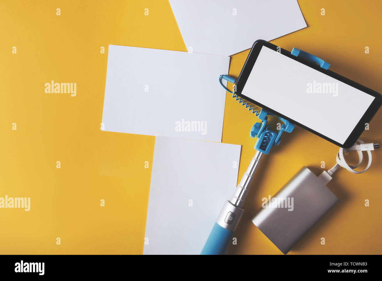 Piatto monopiede laici con uno smartphone e foto su uno sfondo giallo. Estate concetto di viaggio. Foto Stock