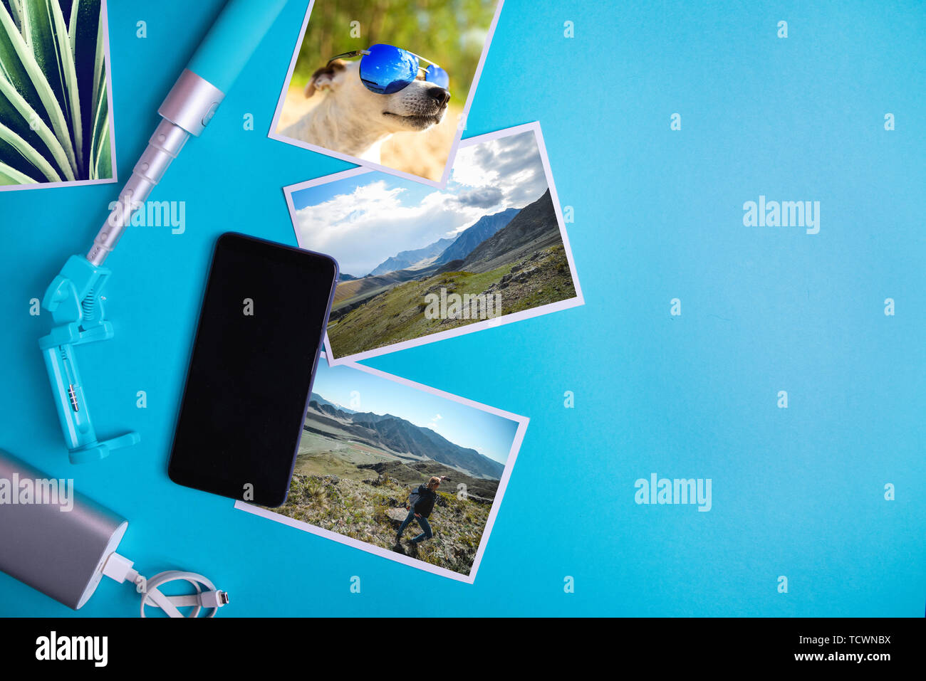 Smartphone con schermo vuoto e volantini e foto su uno sfondo blu. Mock up, piatto laici. La vacanza estiva concetto. Foto Stock