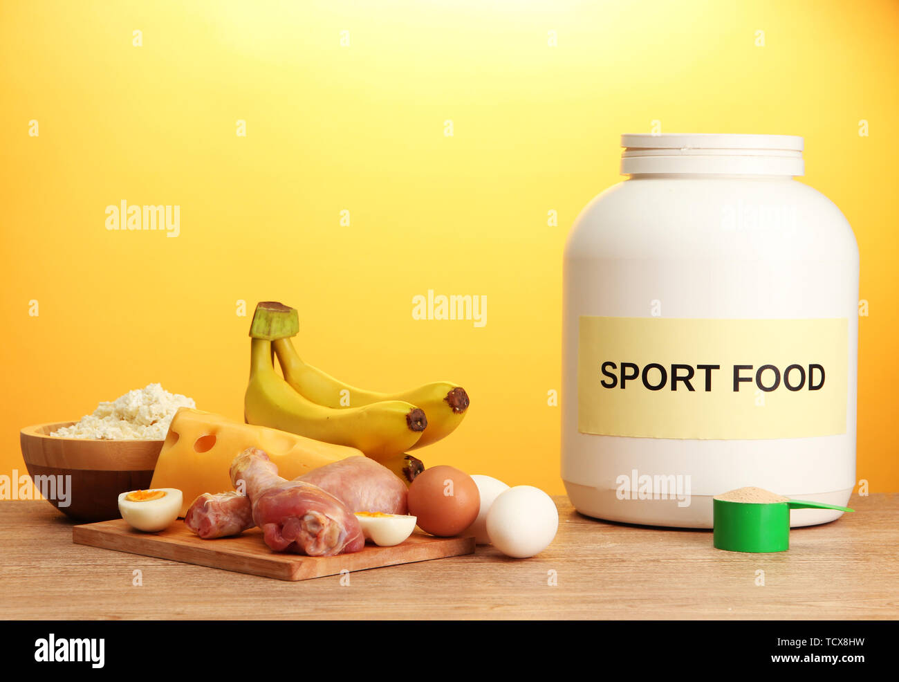Barattolo di proteine in polvere e di alimenti con la proteina, su sfondo  giallo Foto stock - Alamy