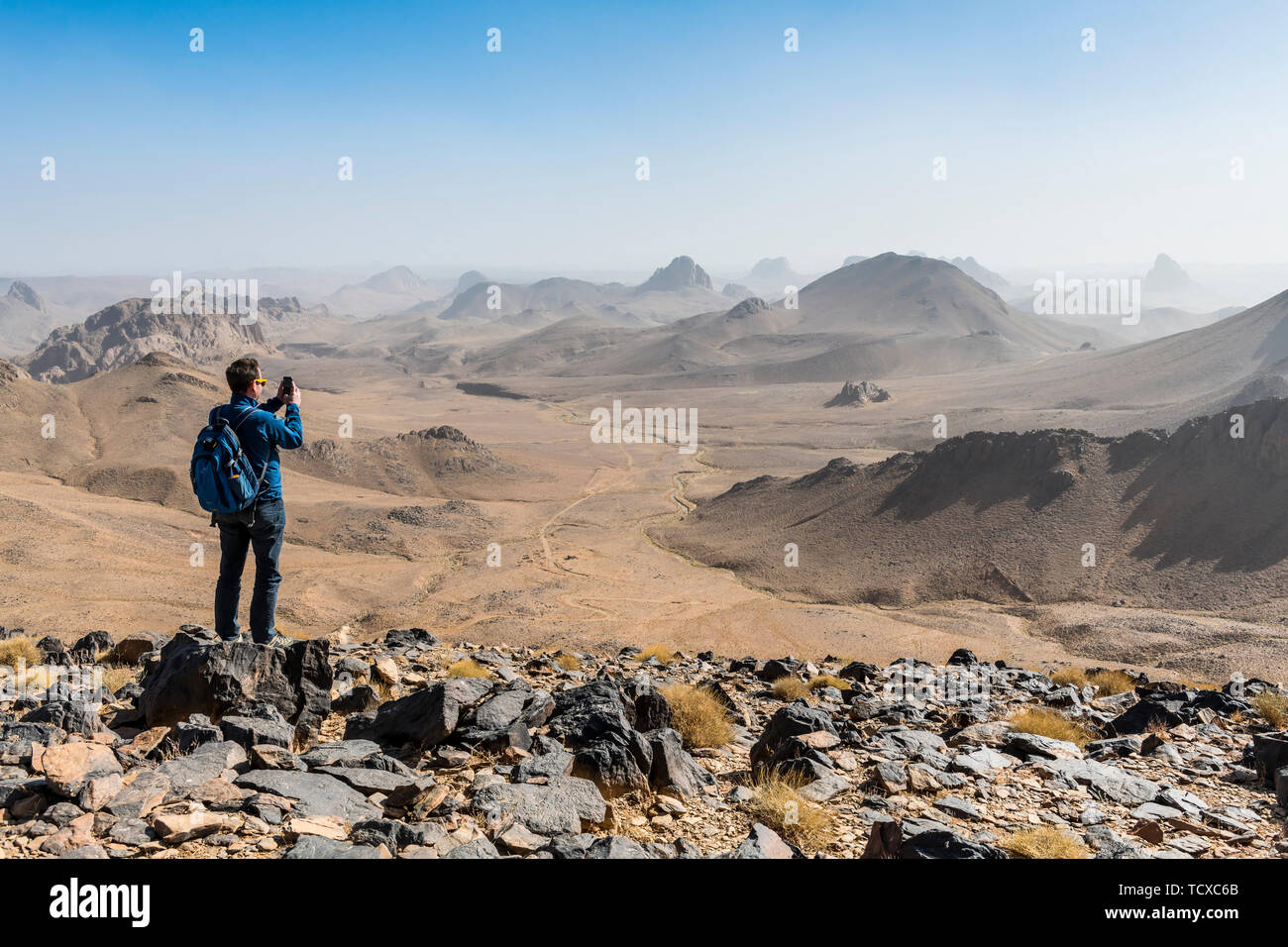 L'uomo godendo il mounains di Assekrem, Tamanrasset, montagne Hoggar, Algeria, Africa Settentrionale, Africa Foto Stock