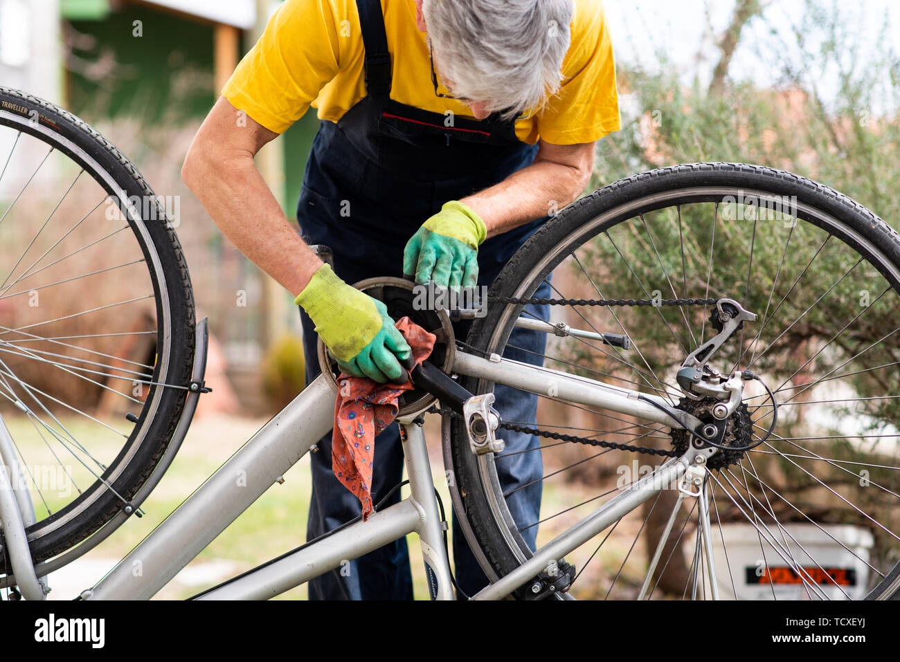 Uomo che pulisce la sua bicicletta per la nuova stagione di guida Foto Stock