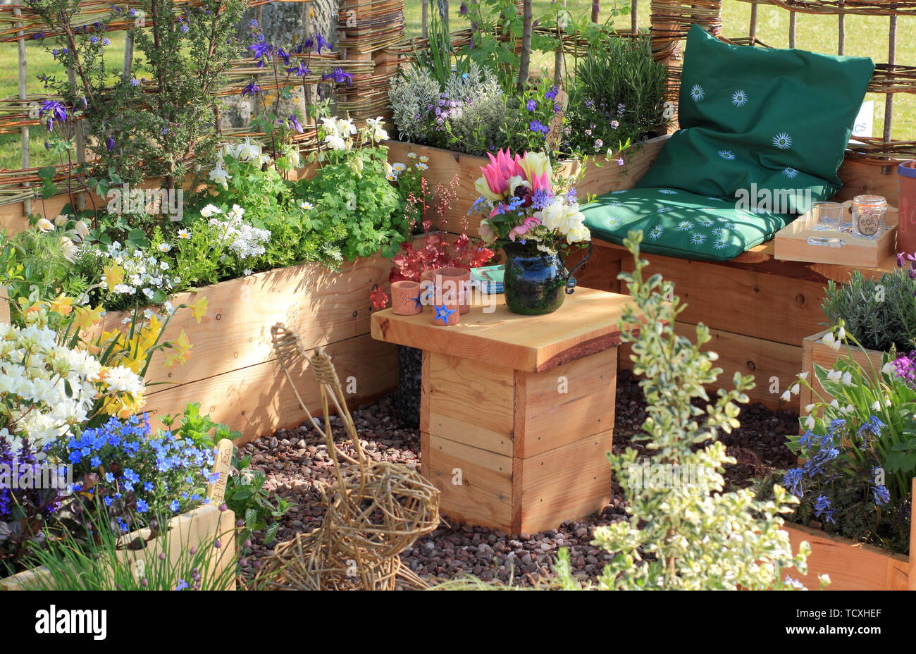 Le piantatrici sollevata e accogliente salotto in un piccolo terreno urbano. Visualizza giardino da giù 2 Massa Garden Design - Harrogate Spring Flower Show 2019 Foto Stock