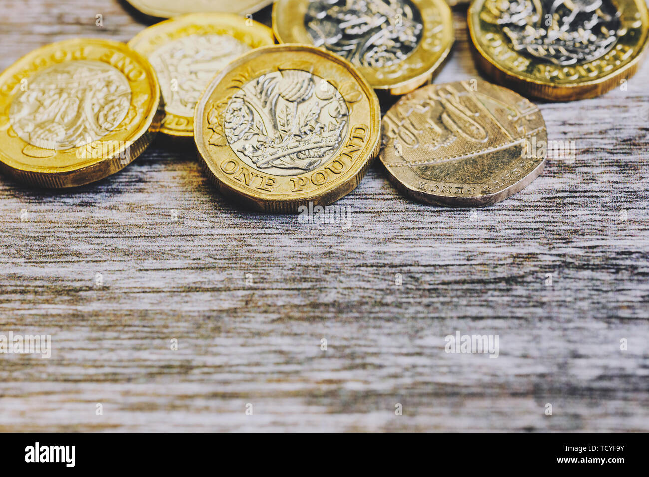 Macro di British una sterlina monete su una superficie di legno Foto Stock