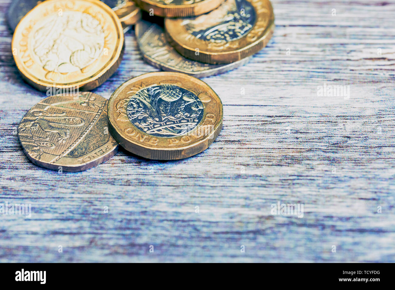 Macro di British una sterlina monete in freddo stile di colore su una superficie di legno Foto Stock