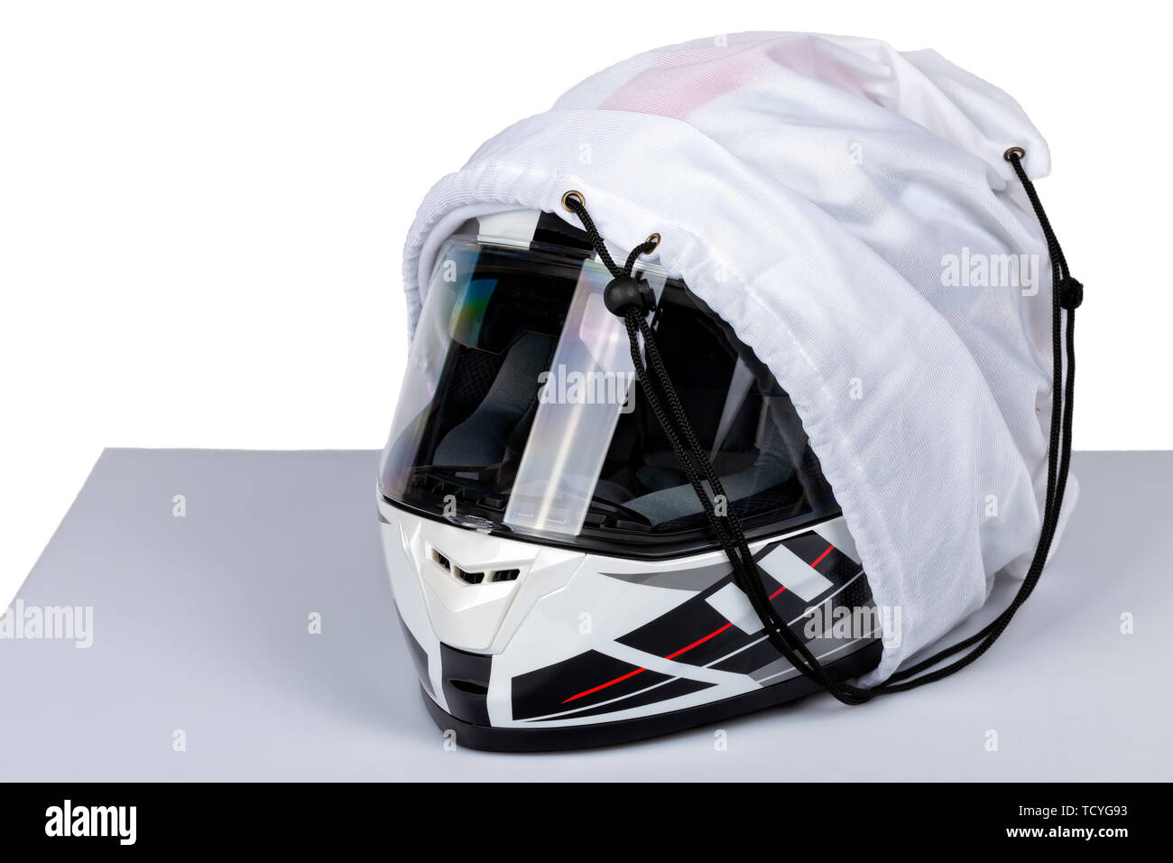 Un casco bianco faccia piena di moto all'interno del suo caso isolato su bianco. Foto Stock