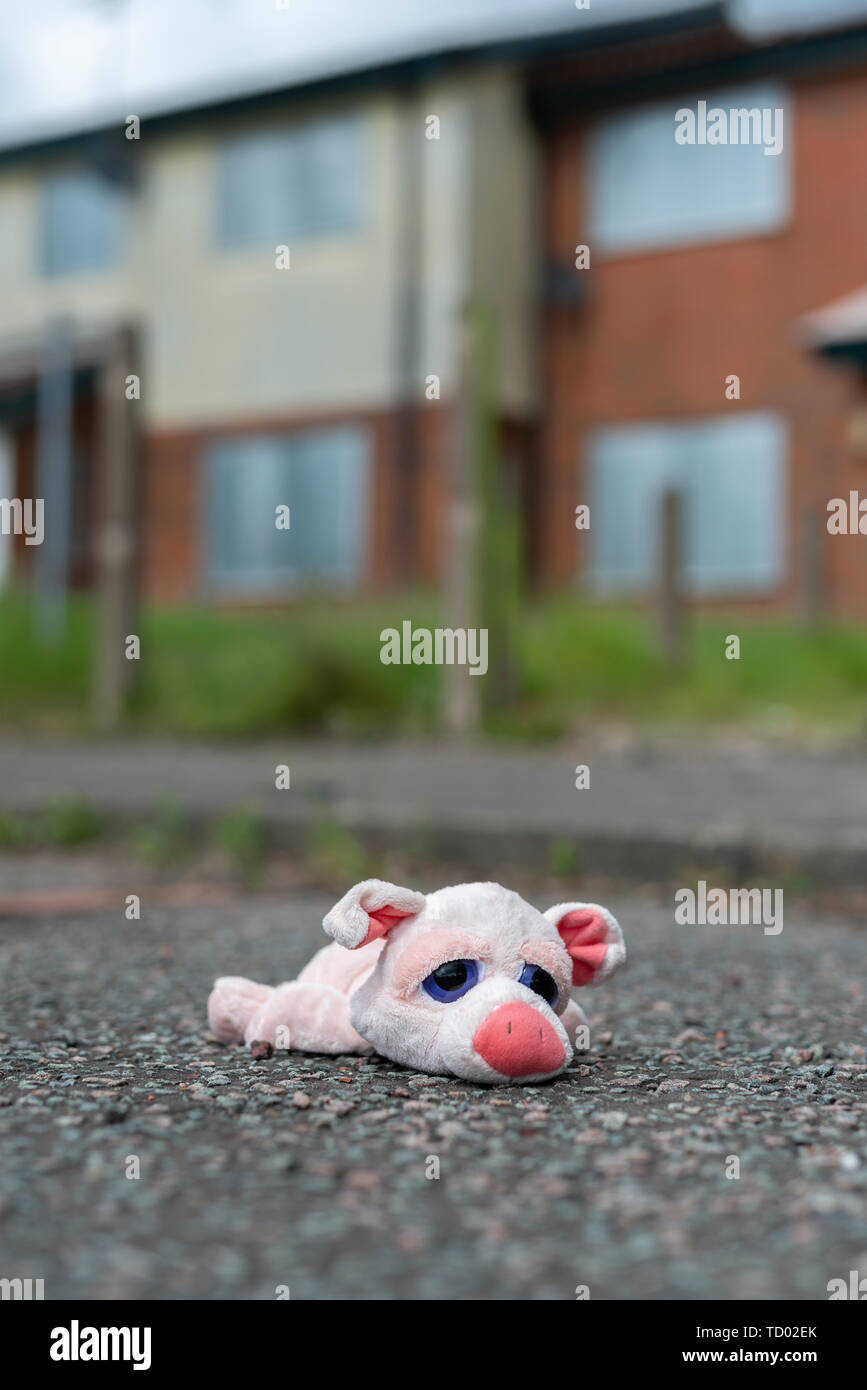 Un bambino giocattolo si trova sul terreno al di fuori alcuni intavolato case abbandonate sulla High Street Station wagon in Pendleton, Salford, Greater Manchester, UK. Foto Stock