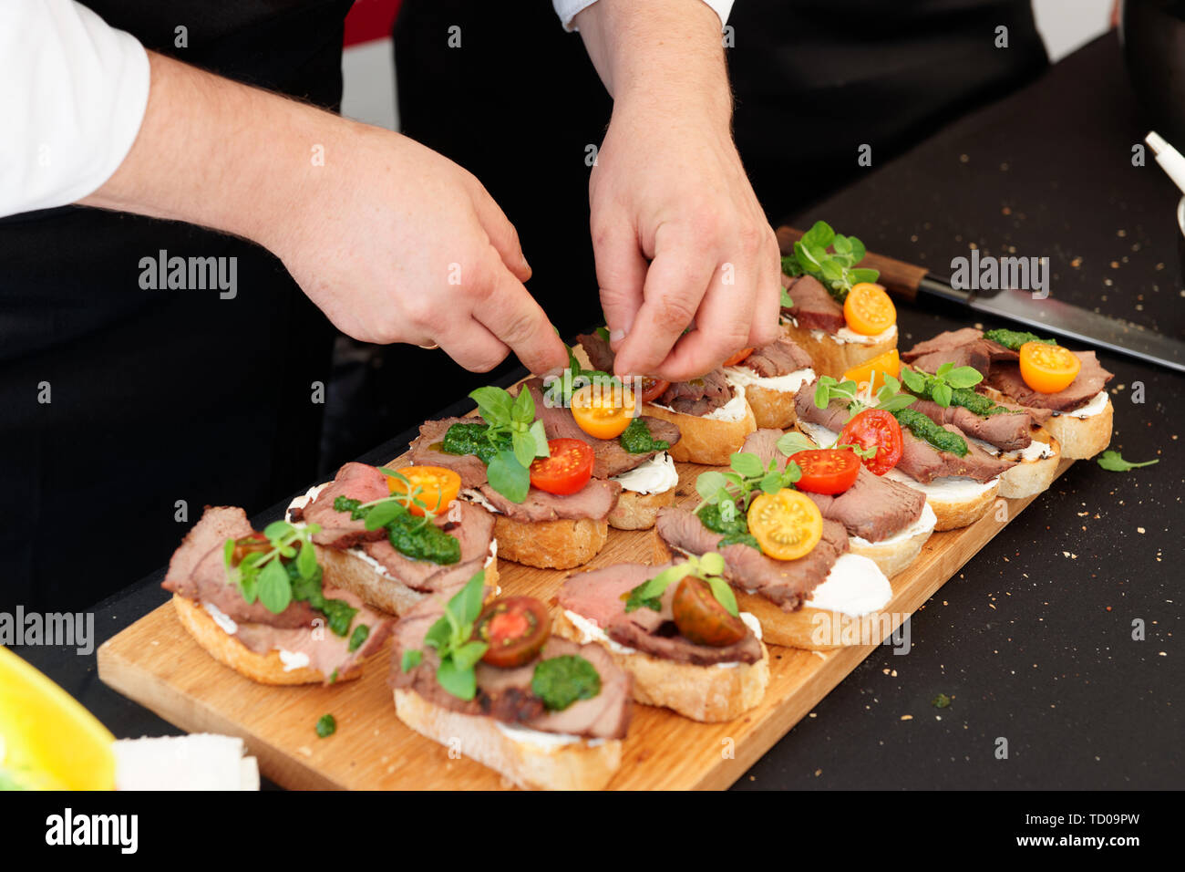 Lo chef è rendere bruschette con bistecca di manzo e pesto Foto Stock